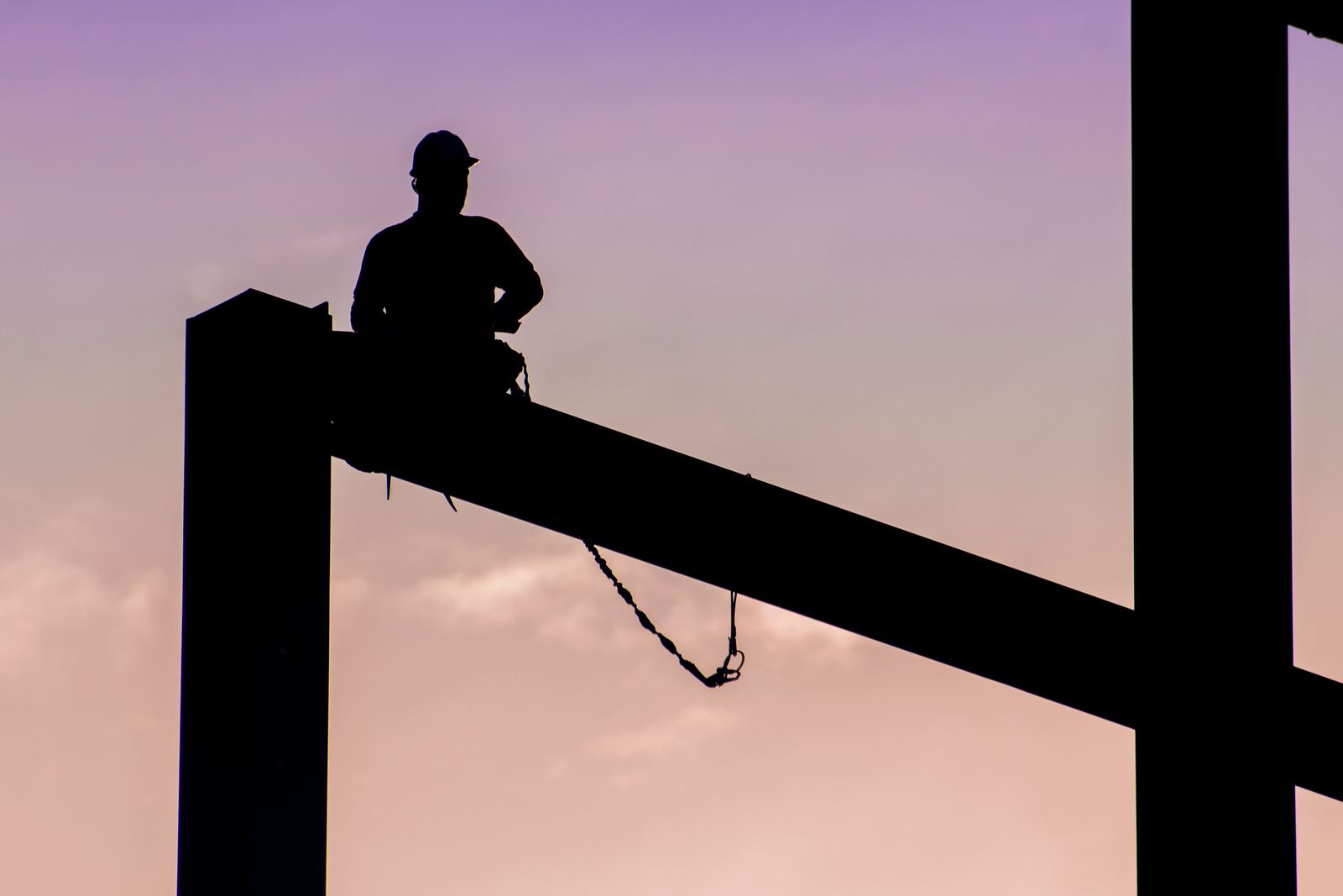 Construction professional at work against an evening sky